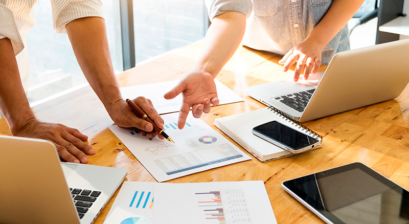 Reunião com documentos e laptops sobre uma mesa